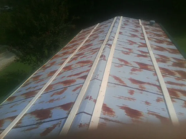 Rusted metal roof panels with new wood purlins before replacement — Storm Damage Roof Repair in Bouton by Roofing Brothers
