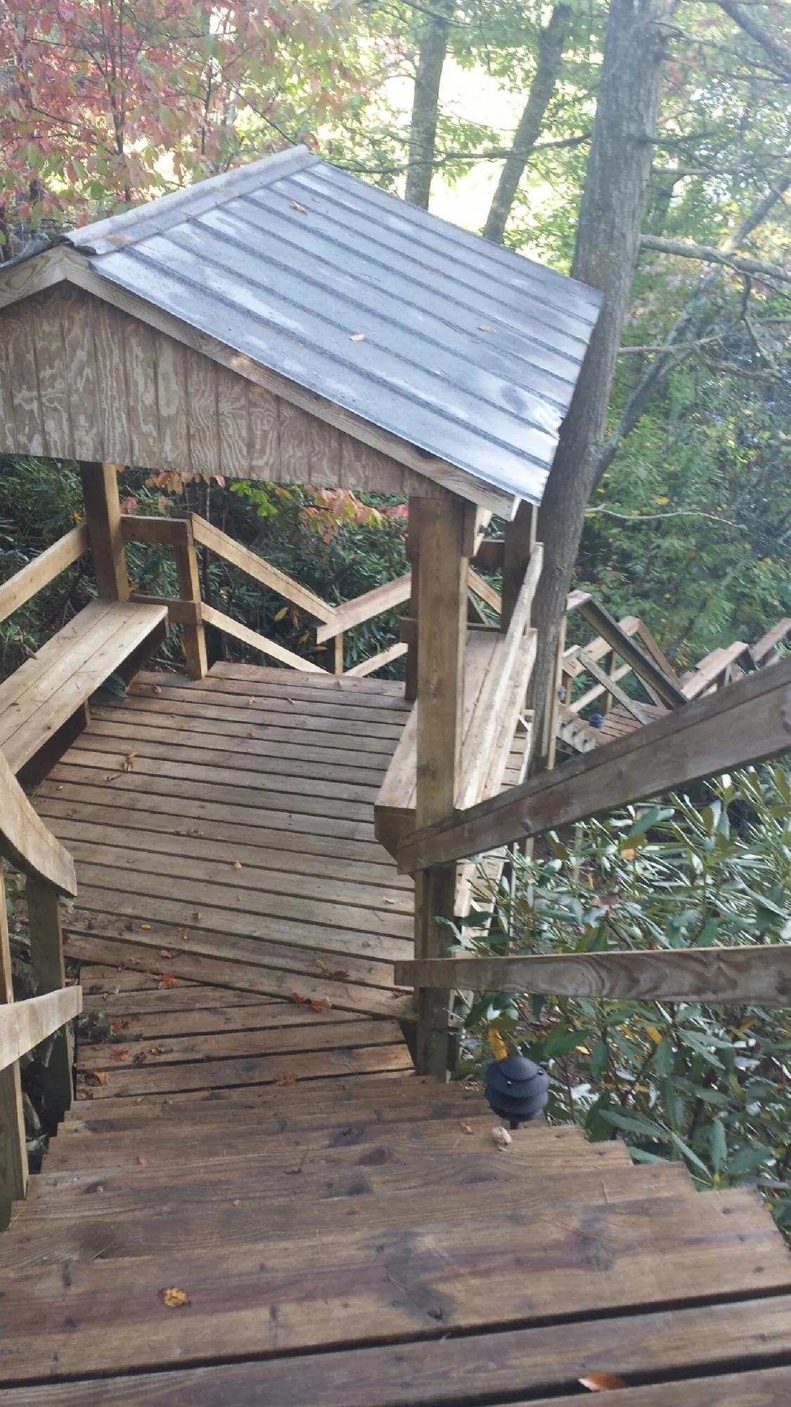 Metal roofed shelter over wooden steps on a wooded walkway — Skylight Repair & Installation work by our crew in Bouton